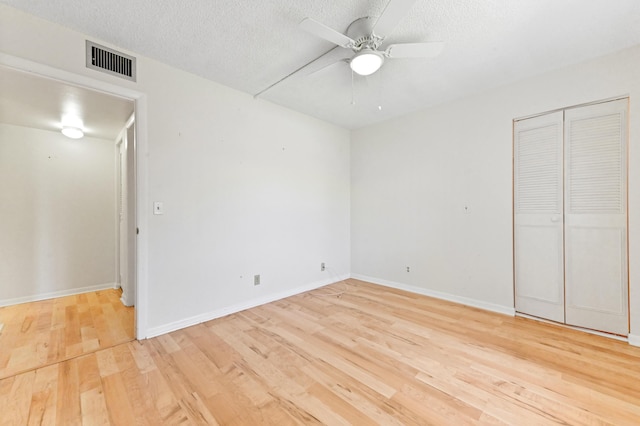 302 Knotty Pine Cir Unit D-1, Greenacres, FL 33463 - unfurnished bedroom with light wood-style flooring, baseboards, a textured ceiling, ceiling fan, and a closet