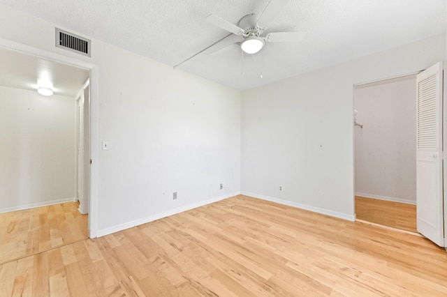 302 Knotty Pine Cir Unit D-1, Greenacres, FL 33463 - unfurnished bedroom featuring light wood-type flooring, baseboards, ceiling fan, a textured ceiling, and a closet