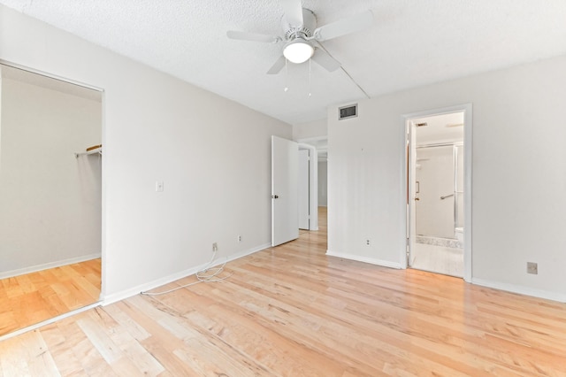 302 Knotty Pine Cir Unit D-1, Greenacres, FL 33463 - unfurnished bedroom featuring light wood-type flooring, a walk in closet, connected bathroom, and baseboards