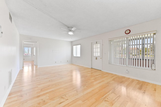 302 Knotty Pine Cir Unit D-1, Greenacres, FL 33463 - unfurnished living room with ceiling fan, wood finished floors, healthy amount of natural light, baseboards, and a textured ceiling