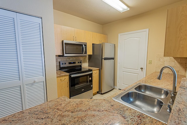 166 SW Peacock Blvd Unit 34-205, Port Saint Lucie, FL 34986 - kitchen featuring stainless steel appliances, light brown cabinetry, a sink, and tasteful backsplash