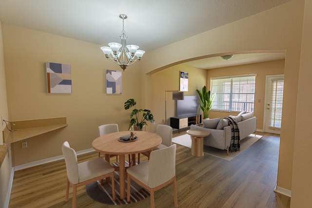 166 SW Peacock Blvd Unit 34-205, Port Saint Lucie, FL 34986 - dining space featuring arched walkways, wood finished floors, a chandelier, and baseboards