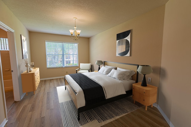 166 SW Peacock Blvd Unit 34-205, Port Saint Lucie, FL 34986 - bedroom with light wood-style floors, a chandelier, baseboards, and a textured ceiling