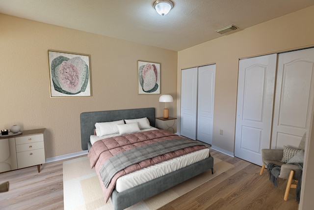 166 SW Peacock Blvd Unit 34-205, Port Saint Lucie, FL 34986 - bedroom featuring two closets, light wood-type flooring, and baseboards