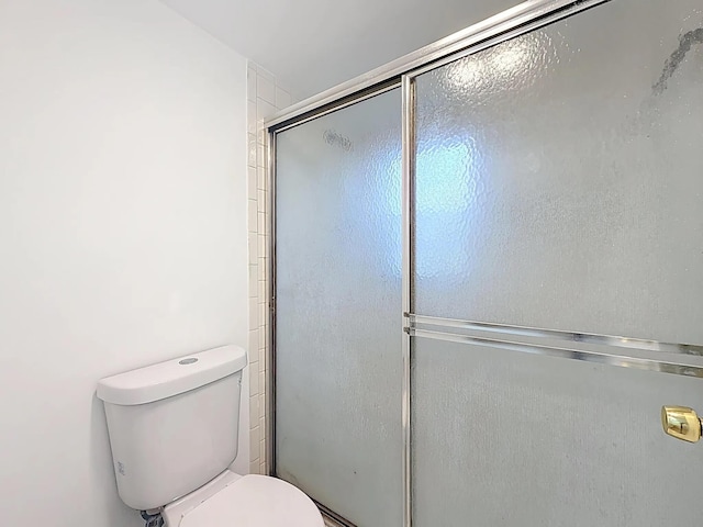 full bathroom with toilet and a shower with door