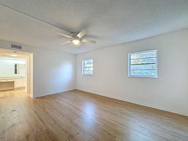 unfurnished room featuring wood finished floors, a textured ceiling, ceiling fan, and baseboards