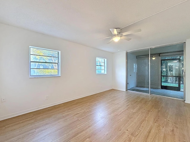 unfurnished bedroom with wood finished floors, a textured ceiling, a closet, baseboards, and ceiling fan