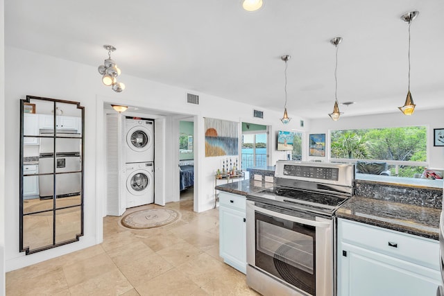 711 NE Harbour Ter Unit 4120, Boca Raton, FL 33431 - kitchen featuring electric stove, stacked washing machine and dryer, hanging light fixtures, white cabinetry, and dark stone countertops