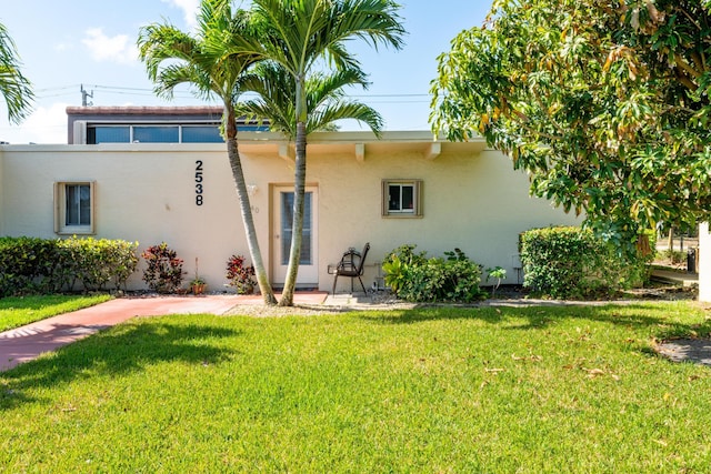 2538 Boundbrook Dr S Unit 140, West Palm Beach, FL 33406 - rear view of property featuring stucco siding and a lawn