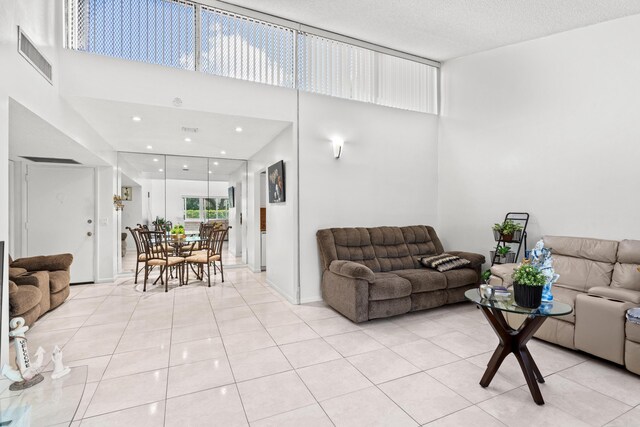 2538 Boundbrook Dr S Unit 140, West Palm Beach, FL 33406 - living room featuring light tile patterned floors, a towering ceiling, and recessed lighting