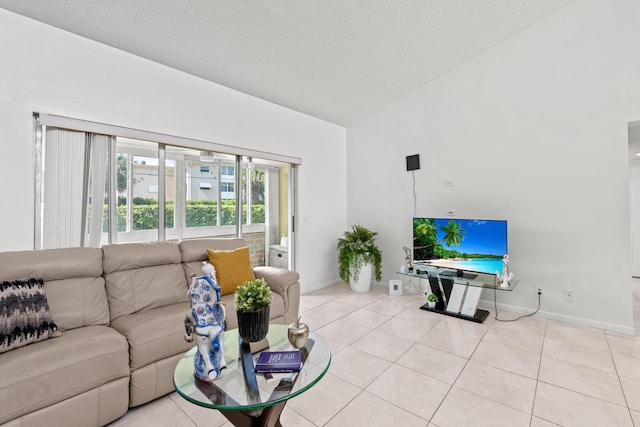 2538 Boundbrook Dr S Unit 140, West Palm Beach, FL 33406 - living room featuring lofted ceiling, baseboards, light tile patterned floors, and a textured ceiling