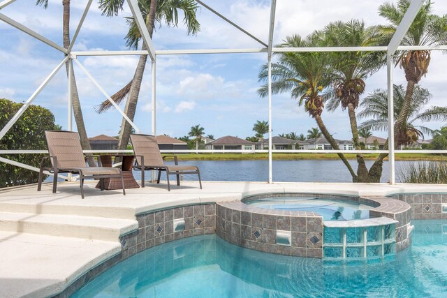 7897 Monarch Ct, Delray Beach, FL 33446 - view of swimming pool featuring a pool with connected hot tub, glass enclosure, a water view, and a patio