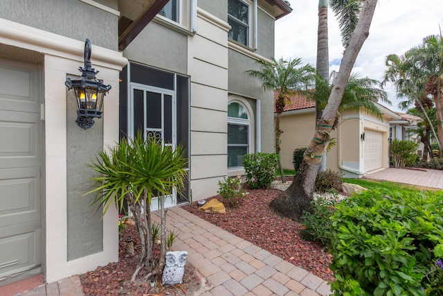 7897 Monarch Ct, Delray Beach, FL 33446 - entrance to property featuring stucco siding, a garage, and driveway
