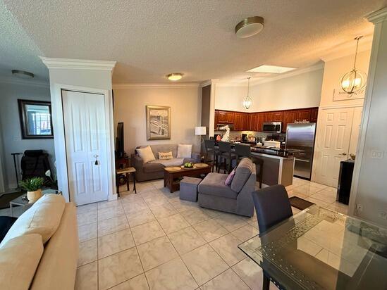 3790 Silver Lace Ln, Boynton Beach, FL 33436 - living room featuring crown molding, a textured ceiling, and a chandelier