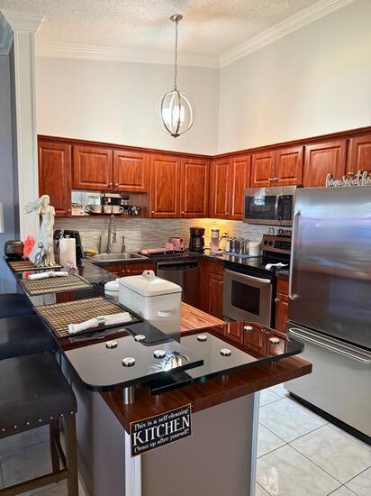 3790 Silver Lace Ln, Boynton Beach, FL 33436 - kitchen featuring appliances with stainless steel finishes, crown molding, dark countertops, backsplash, and a textured ceiling