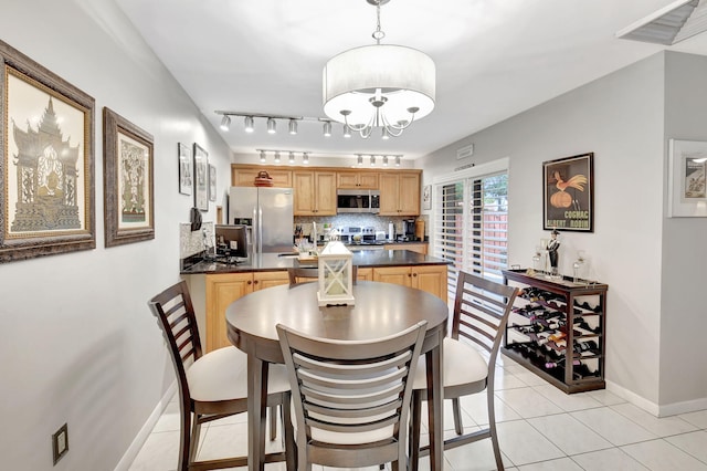 dining area featuring baseboards, light tile patterned floors, and a chandelier
