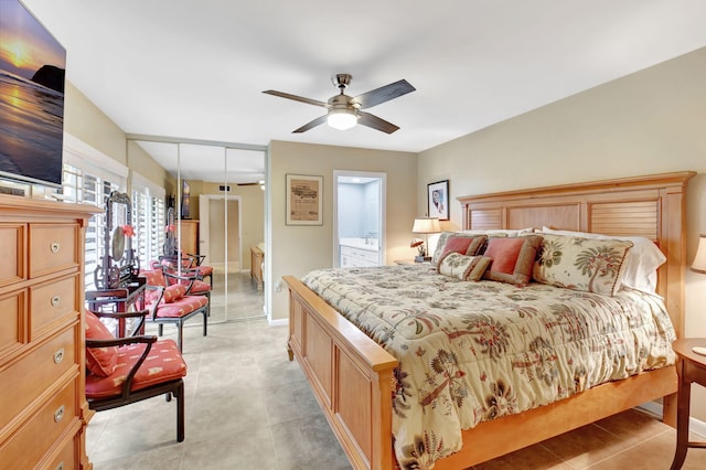 bedroom featuring ensuite bath, baseboards, ceiling fan, and light tile patterned flooring