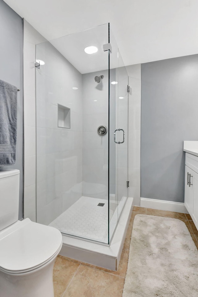 full bathroom with tile patterned flooring, a shower stall, toilet, and vanity