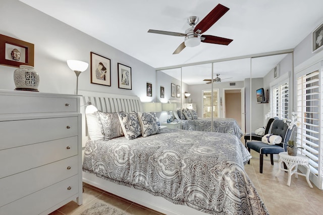 bedroom featuring light tile patterned floors, ceiling fan, and a closet
