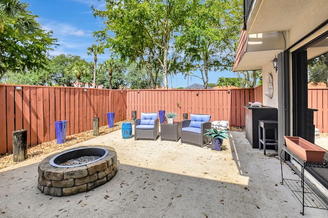 view of patio / terrace featuring a fenced backyard and an outdoor living space with a fire pit