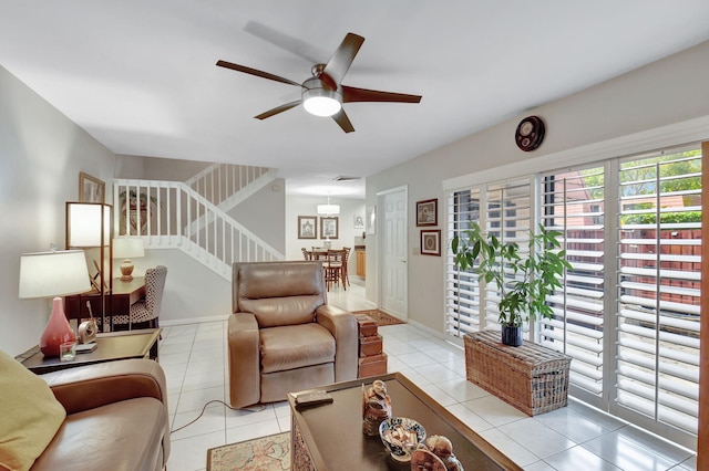 living room featuring ceiling fan, stairs, and light tile patterned floors