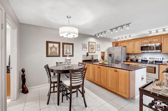 kitchen featuring appliances with stainless steel finishes, dark countertops, a peninsula, and tasteful backsplash