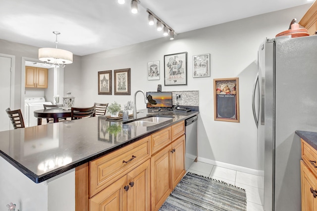 kitchen with stainless steel appliances, a sink, light tile patterned floors, a peninsula, and baseboards