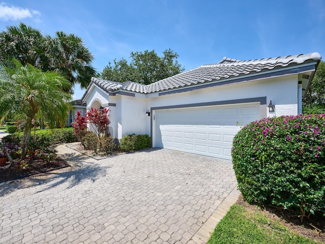 5455 S Fountains Dr S, Lake Worth, FL 33467 - view of front of house featuring decorative driveway, an attached garage, stucco siding, and a tile roof