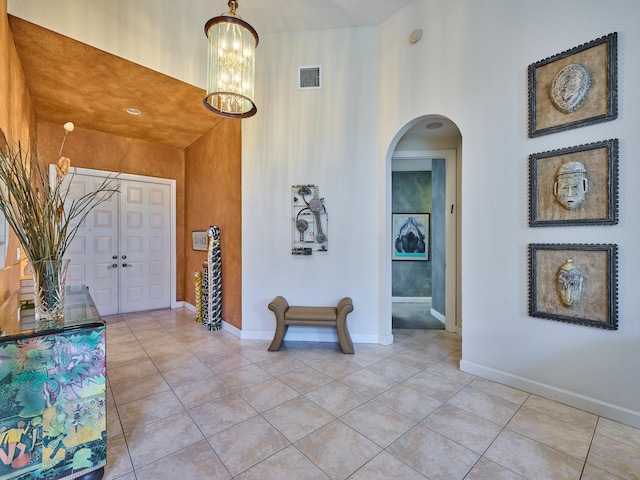 5455 S Fountains Dr S, Lake Worth, FL 33467 - entryway featuring arched walkways, light tile patterned flooring, a chandelier, baseboards, and a towering ceiling