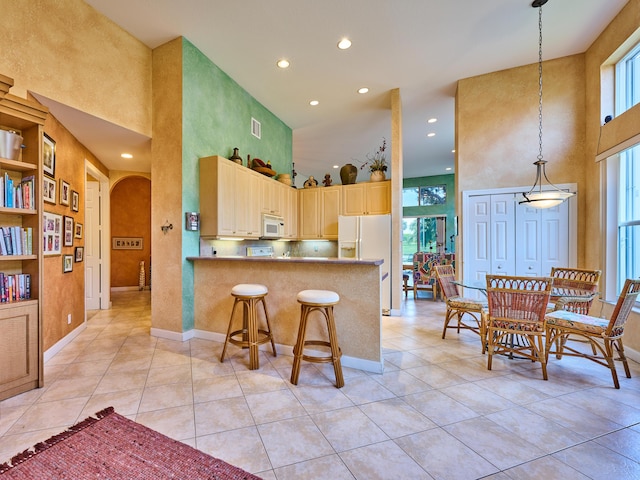 5455 S Fountains Dr S, Lake Worth, FL 33467 - kitchen with a towering ceiling, white appliances, arched walkways, light tile patterned flooring, and recessed lighting