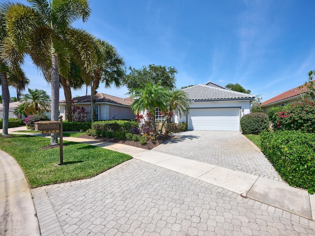5455 S Fountains Dr S, Lake Worth, FL 33467 - view of front of home featuring stucco siding, decorative driveway, a front yard, an attached garage, and a tile roof