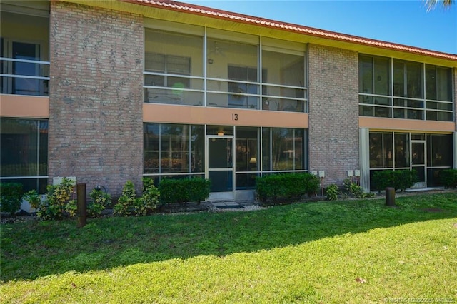 1925 SW Palm City Rd Unit C, Stuart, FL 34994 - rear view of house featuring a yard and brick siding
