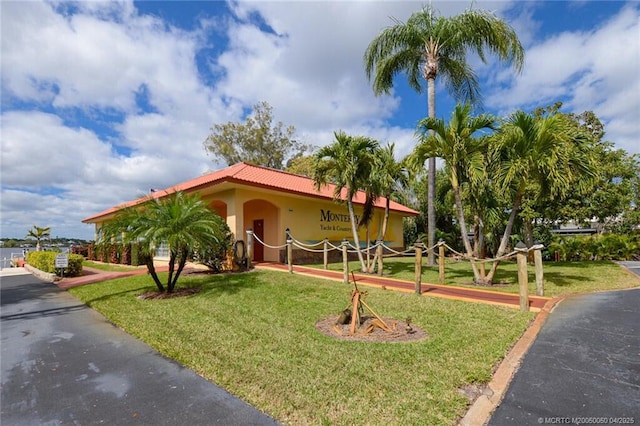 1925 SW Palm City Rd Unit C, Stuart, FL 34994 - mediterranean / spanish home featuring a front lawn, a tiled roof, and stucco siding