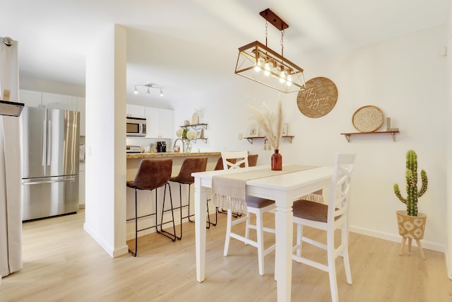 dining space with light wood-style flooring