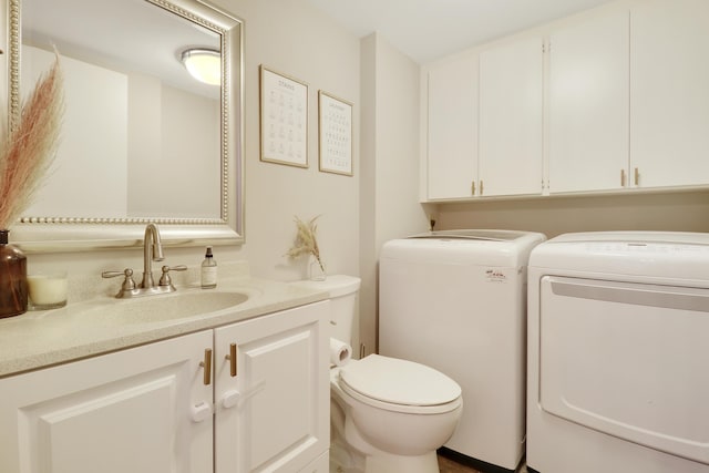 half bath with independent washer and dryer, vanity, and toilet