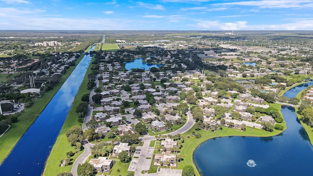 aerial view of property and surrounding area featuring a large body of water and nearby suburban area
