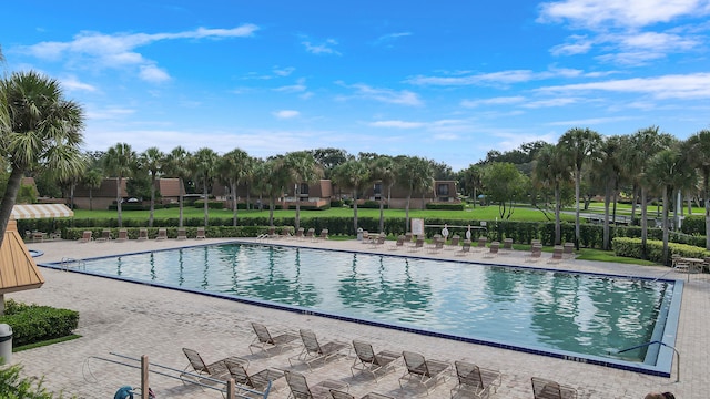 community pool with a patio and fence