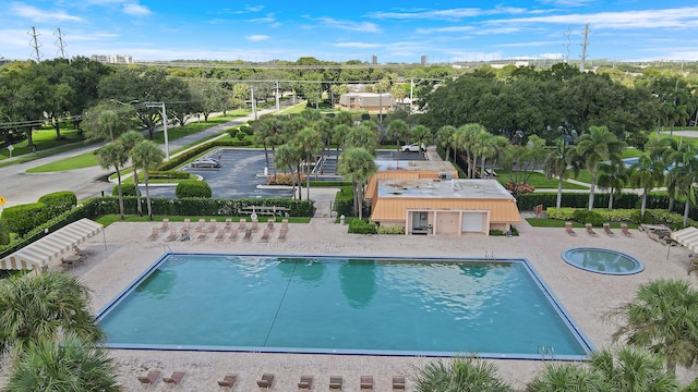 community pool featuring a community hot tub, a patio, and view of scattered trees