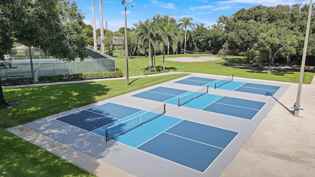 view of community with a tennis court, volleyball court, and view of scattered trees