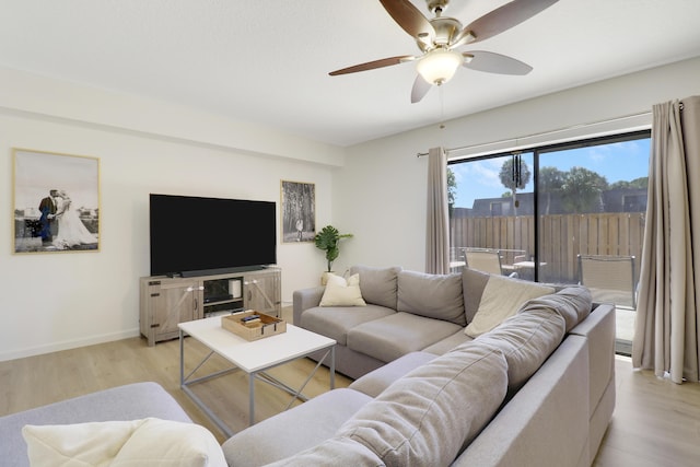living room featuring light wood finished floors, ceiling fan, and baseboards