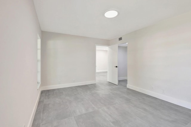 unfurnished room with baseboards