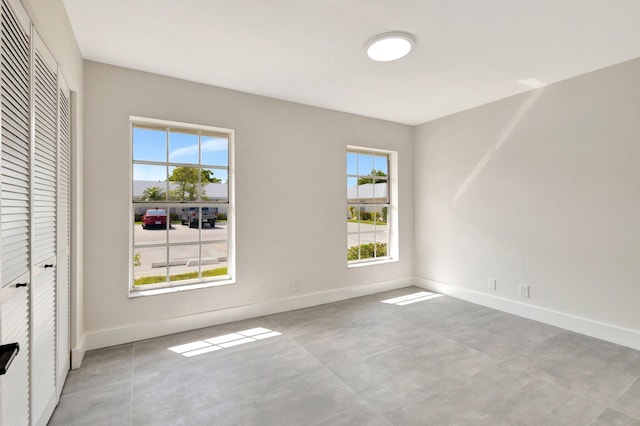 unfurnished bedroom featuring baseboards, a closet, and concrete flooring