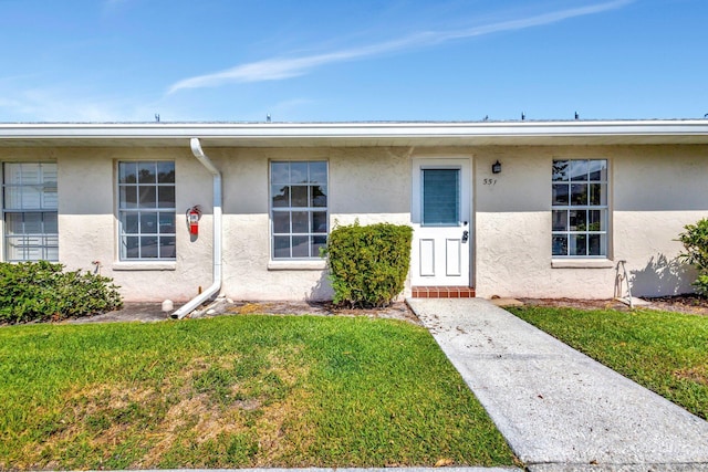 view of front of property with stucco siding and a front yard
