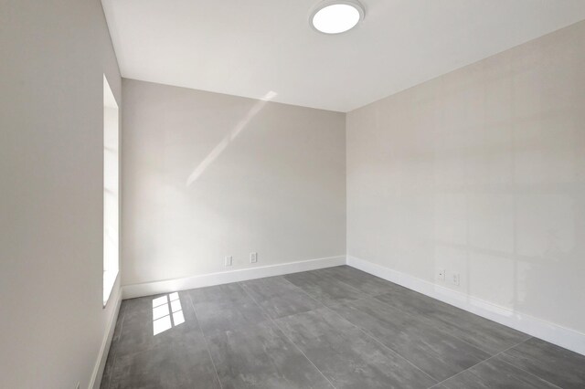 spare room with baseboards