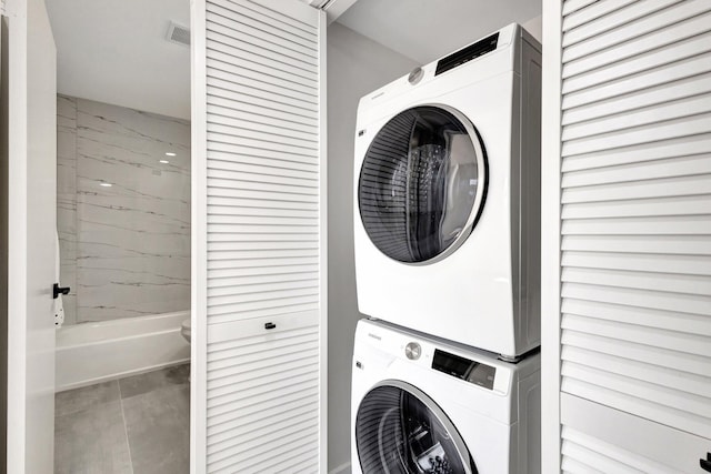 clothes washing area featuring estacked washer and dryer