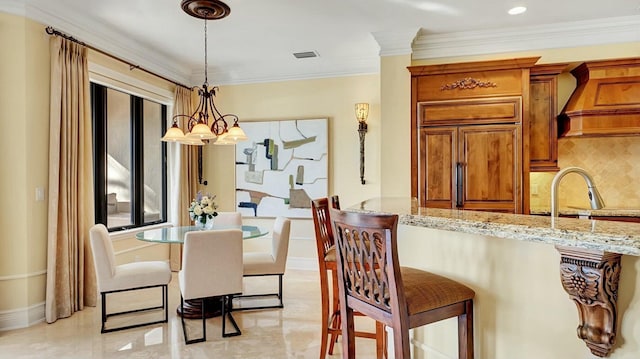 dining space with crown molding and a chandelier