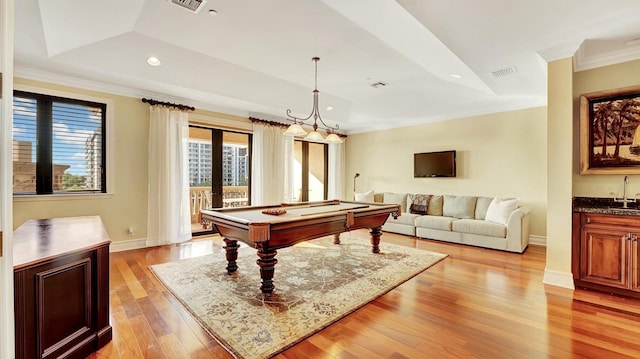 recreation room featuring a raised ceiling, a sink, crown molding, billiards table, and french doors