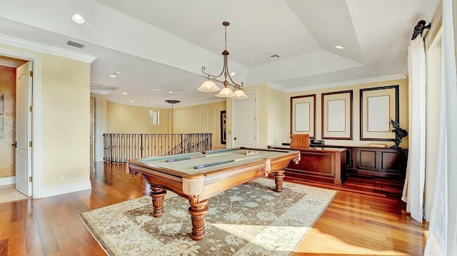 recreation room featuring light wood finished floors, a raised ceiling, billiards table, ornamental molding, and baseboards