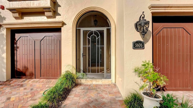 property entrance featuring stucco siding and a gate