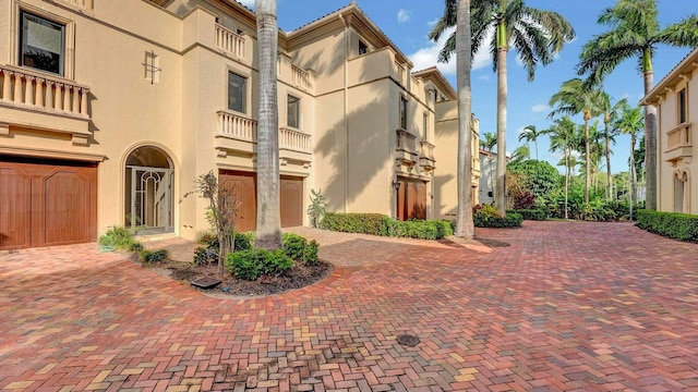view of community with a garage and decorative driveway